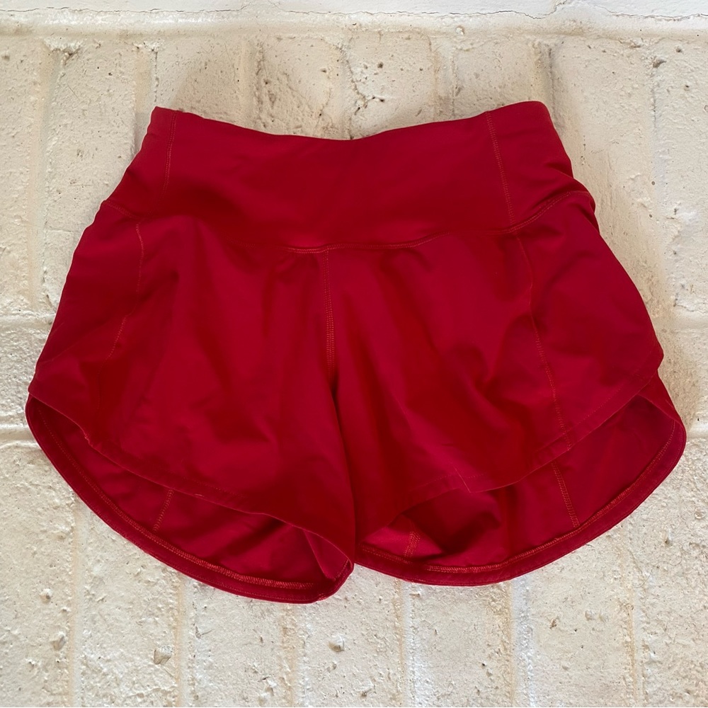 Red Lululemon running shorts, size 0.